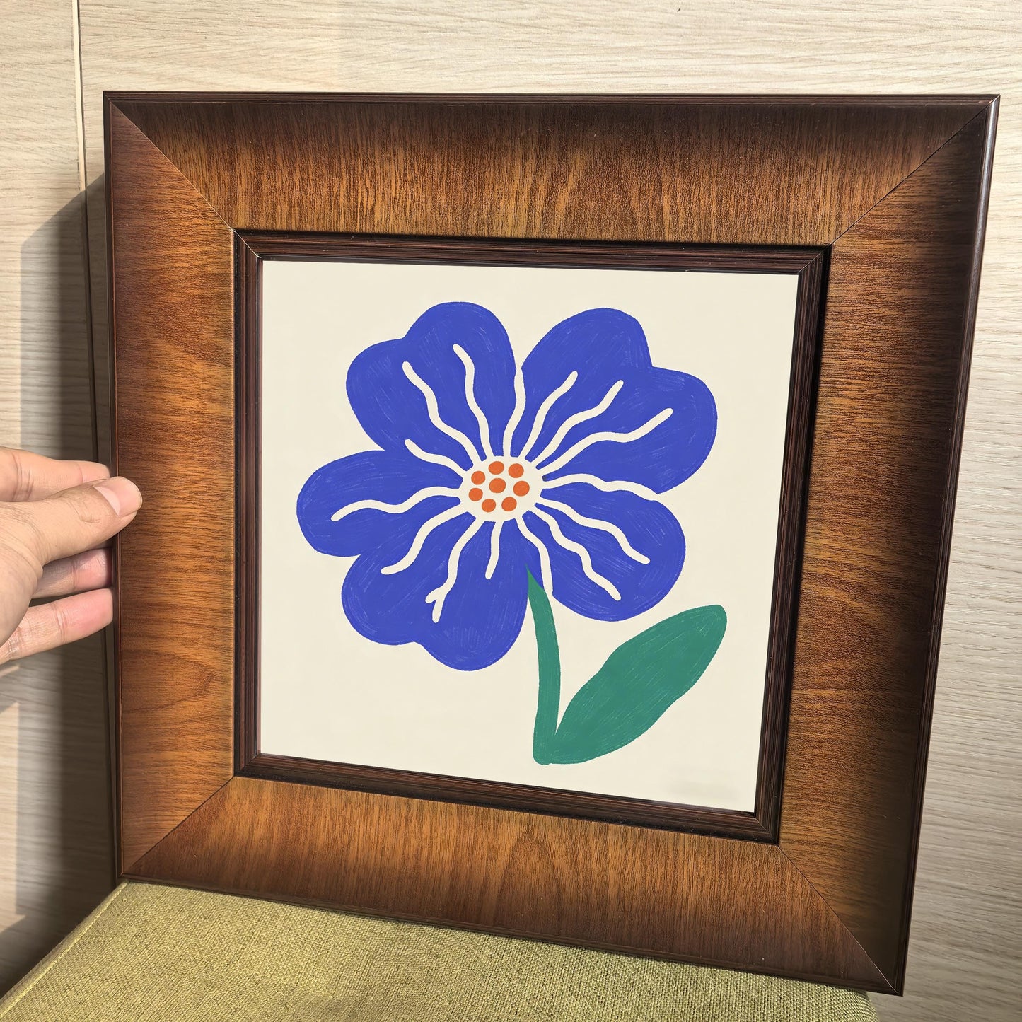 Close-up of a high-quality wood-framed art piece with a blue botanical illustration, showing the sturdy mitered corners of the frame.