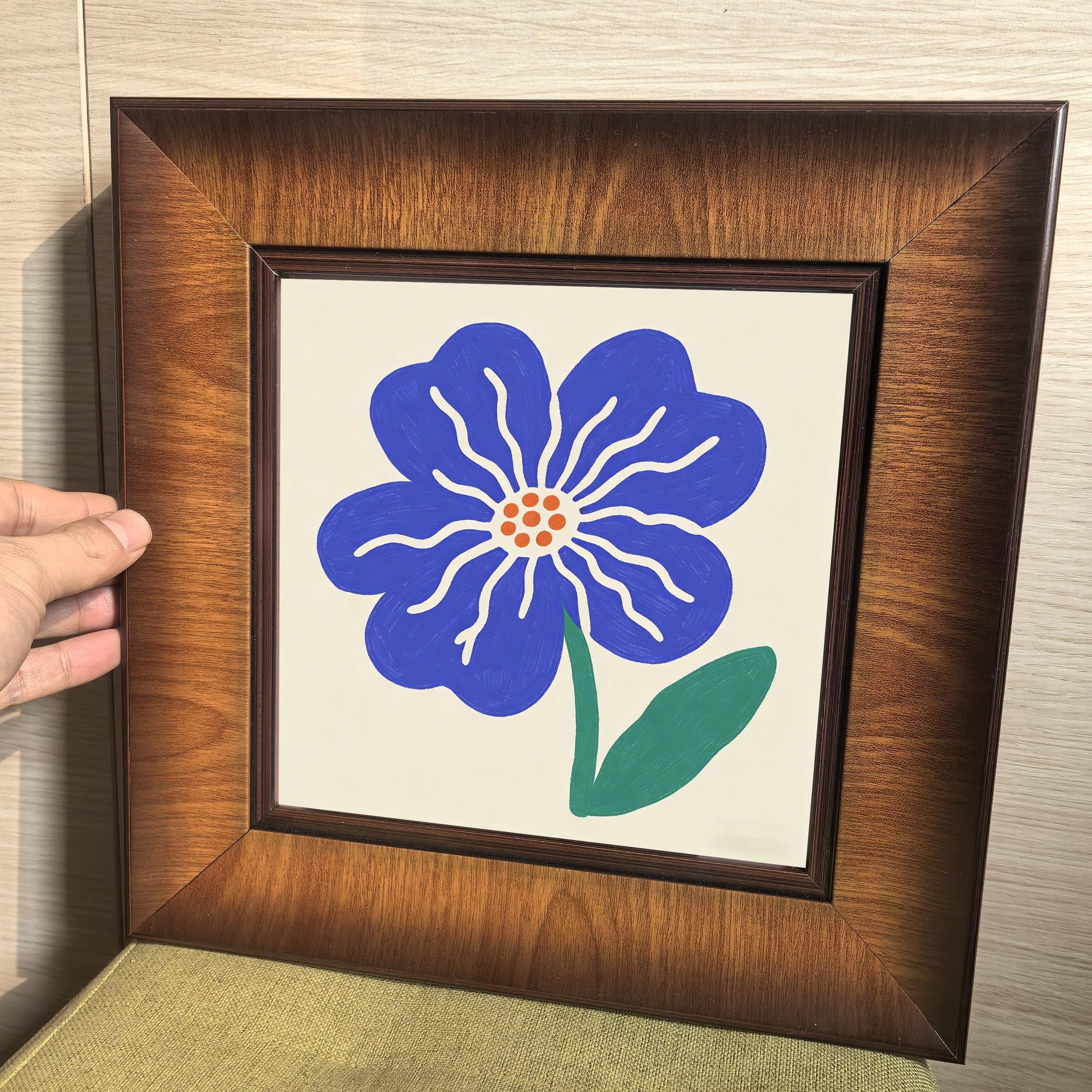 Close-up of a high-quality wood-framed art piece with a blue botanical illustration, showing the sturdy mitered corners of the frame.