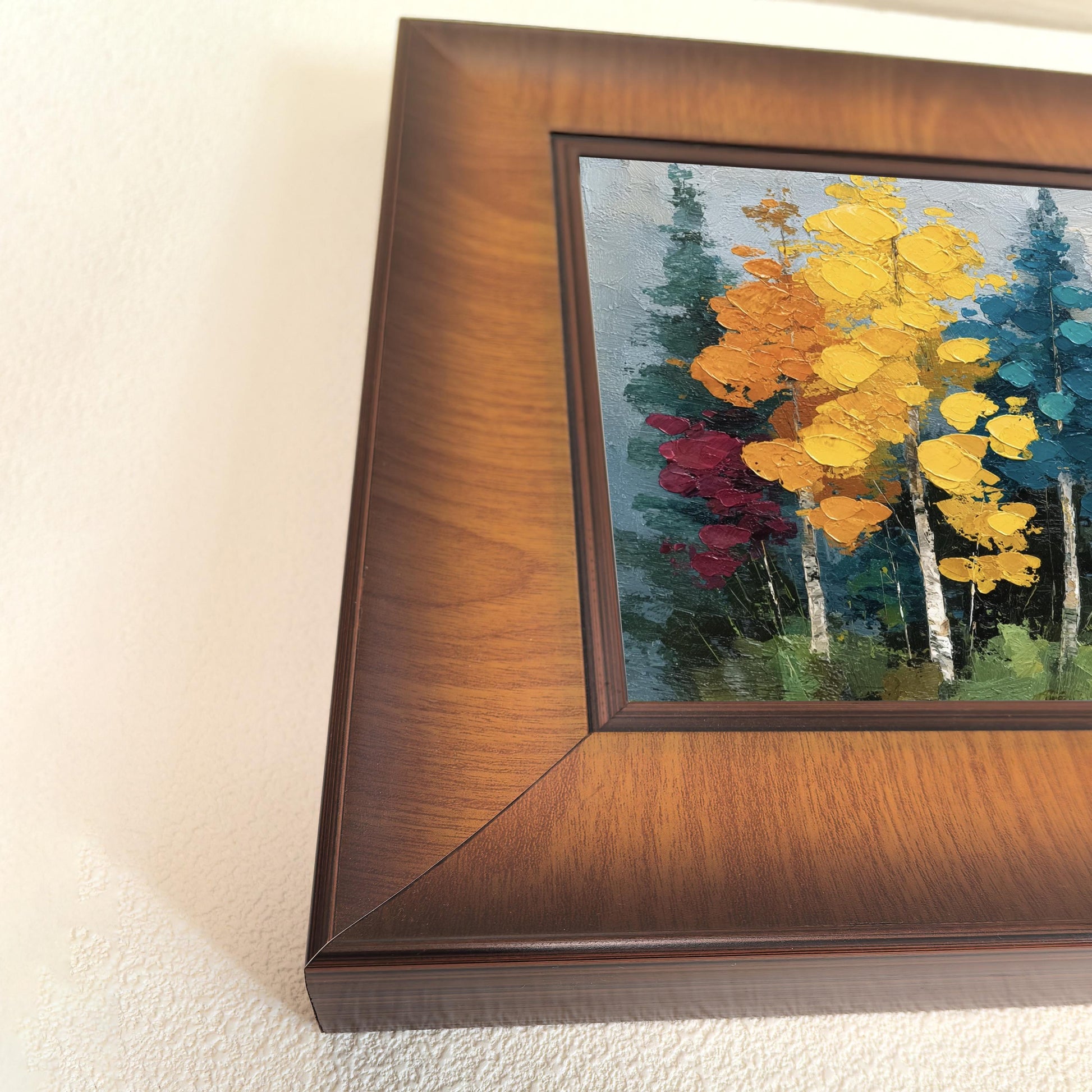 Close-up angled shot showing the wood grain and deep profile of the square frame surrounding a colorful impasto nature print.