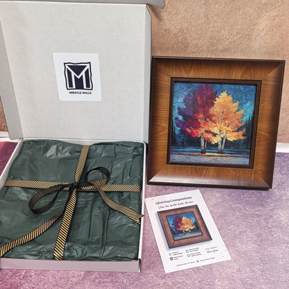 A detailed, front-facing view of the "Glowing Companions" artwork. It features two trees with vibrant, textured red and yellow leaves against a dark teal background, all within a thick, natural wood frame.