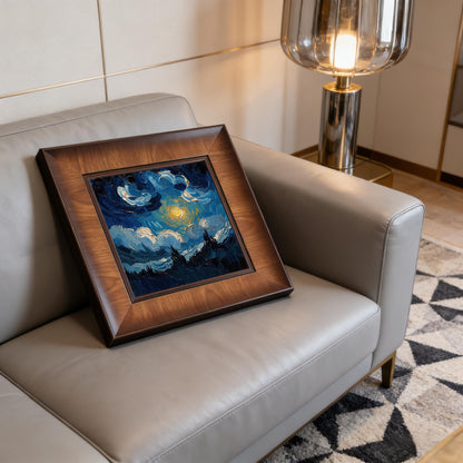 A square wood-framed impasto painting of a starry night sky leaning against the back of a modern grey leather sofa in a well-lit living room with a designer floor lamp.
