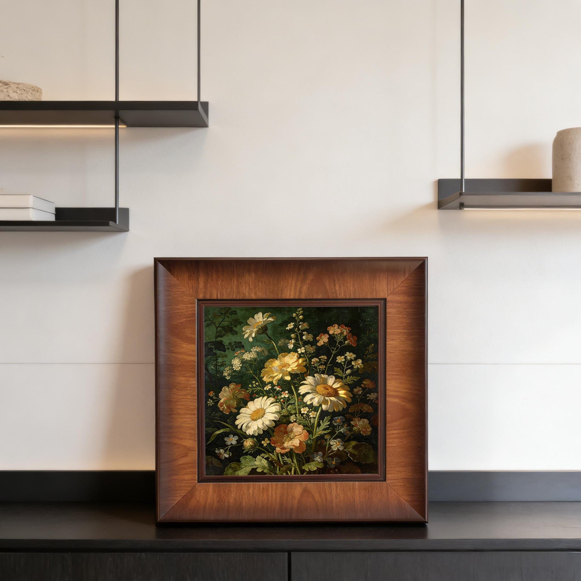Square framed floral art displayed on a sleek black sideboard beneath minimalist floating shelves, showcasing a contemporary interior design style.
