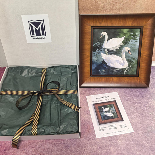 An unboxing display showing the "Graceful Duet" framed print next to its open "Miracle Walls" gift box. The packaging includes premium green tissue paper and a gold-striped black ribbon, with a product info card placed in the foreground.