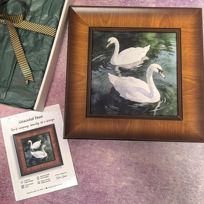 A front-facing view of the "Graceful Duet" art print in a wide, dark wood frame. The artwork features two elegant white swans swimming peacefully on dark, rippling water, rendered in a detailed giclée style.